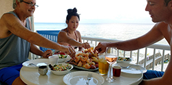 3 people enjoying seafood boil on deck of Seaside Park vacation rental
